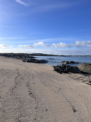A beach with a rocky shoreline, clear sky, and distant hills. - Village Centre Haven One Bed Apartment (Clifden)