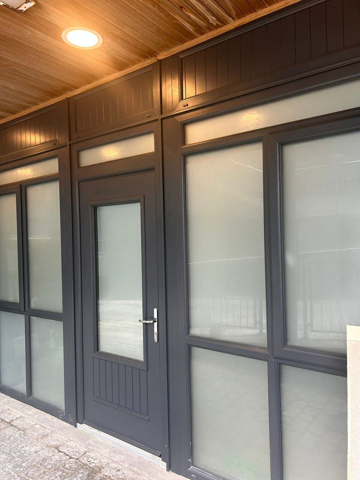 A garage with frosted glass doors and a wooden ceiling.