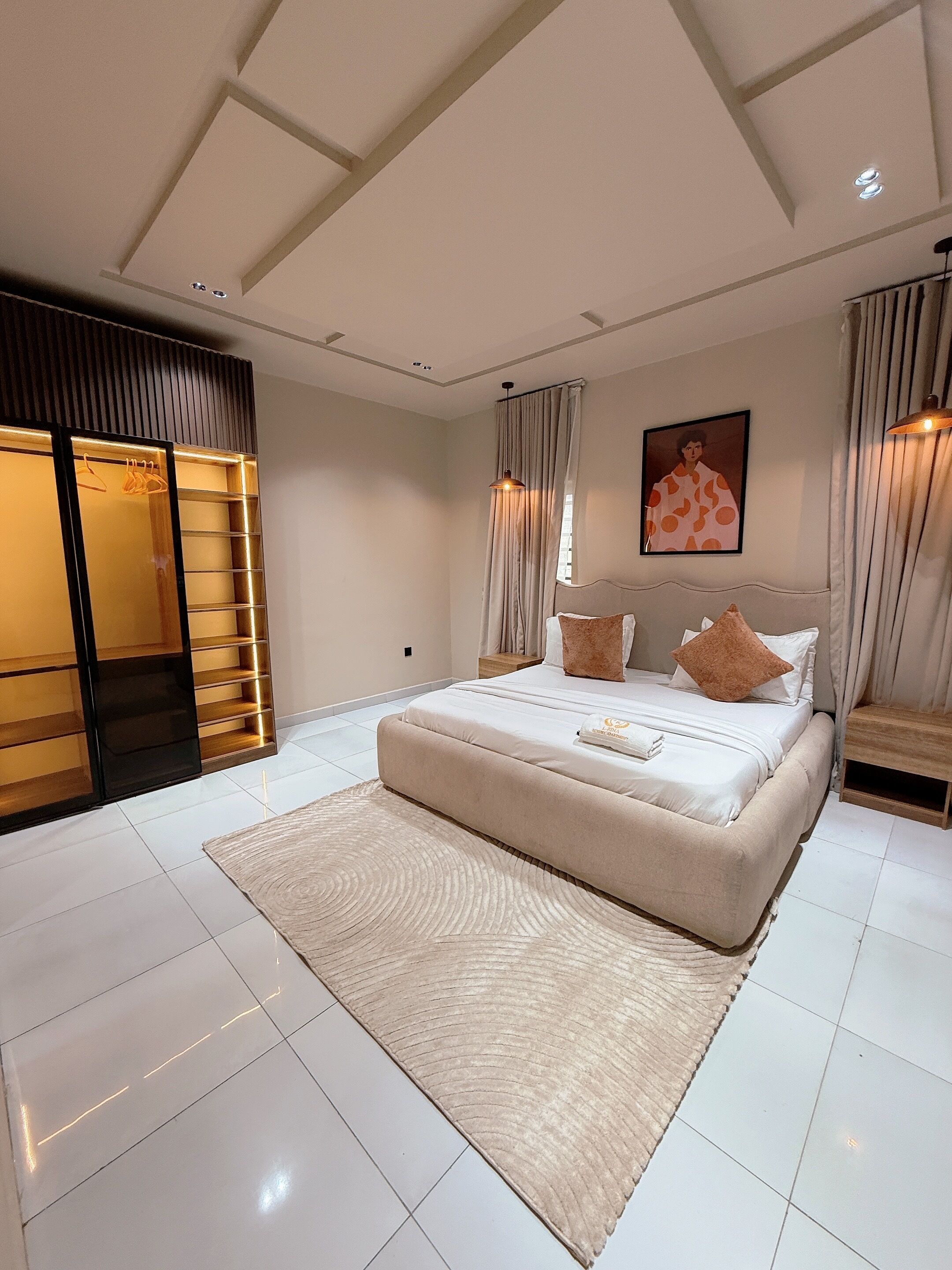 Un dormitorio moderno con una cama grande, armario empotrado e iluminación empotrada en el techo.