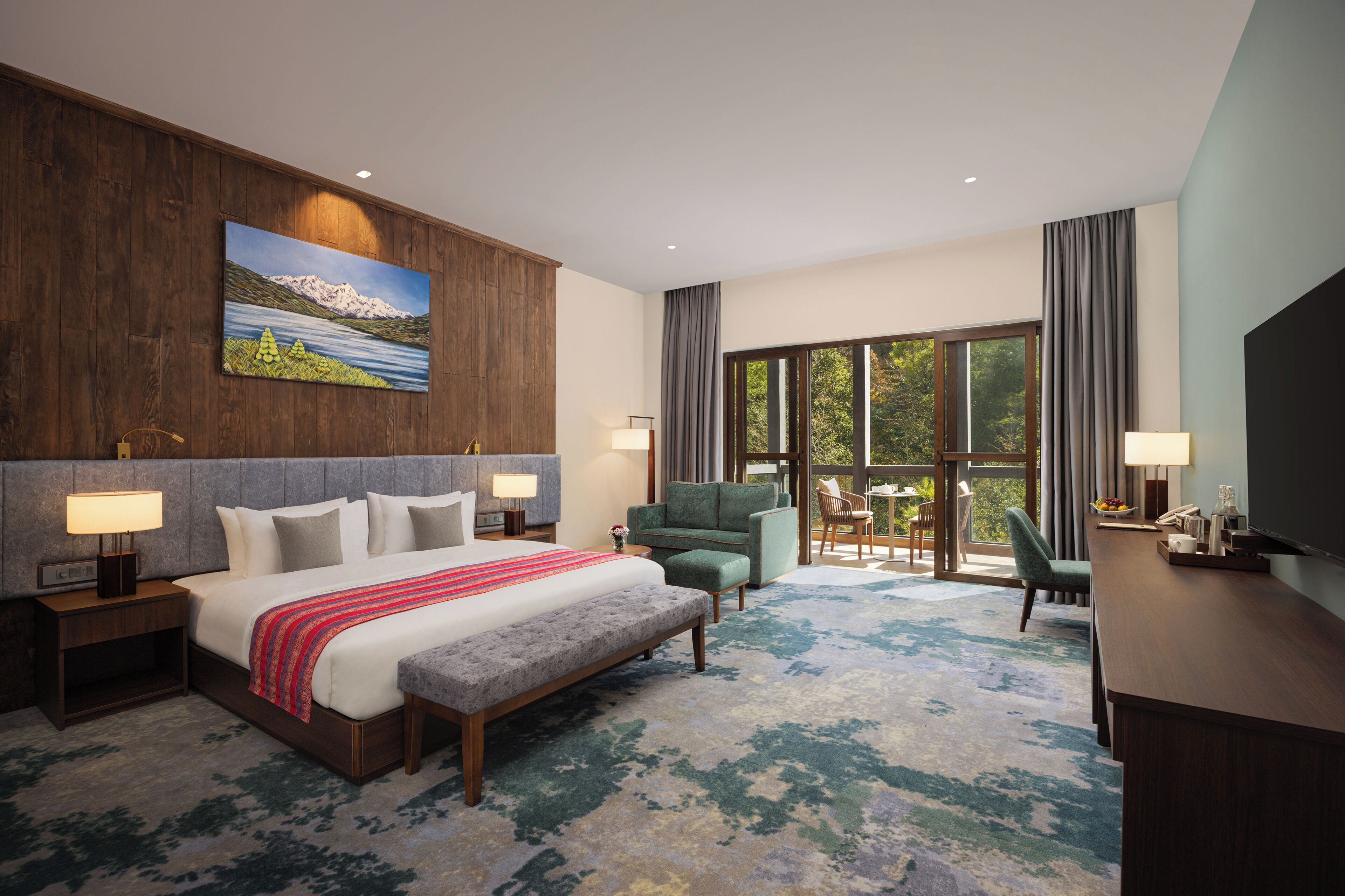 A hotel room with a large bed, a desk, a chair, a television, and a painting on the wall.