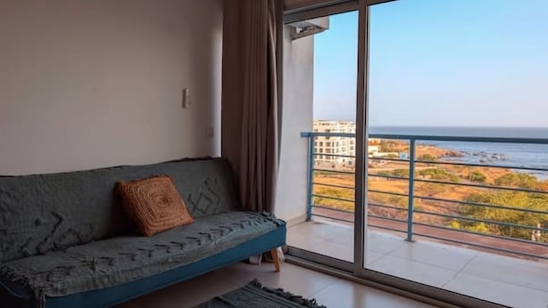 Un balcon avec vue sur la mer et les bâtiments.