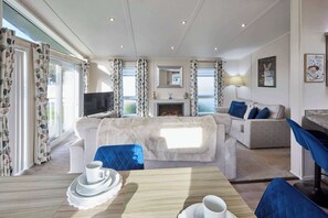 Ein Wohnzimmer mit Kamin, Fernseher und einer Couch.