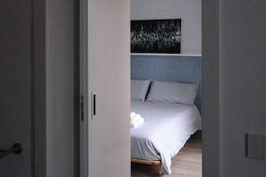 A bedroom with a bed, a painting on the wall, and a door. - B&b Colori del lago (Brebbia)