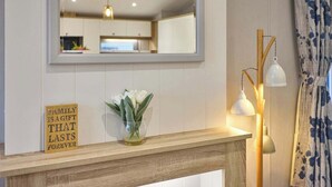 A kitchen with a wooden countertop, a mirror, a vase with flowers, and a sign. - Host & Stay | The Haven Lodge (Pocklington)