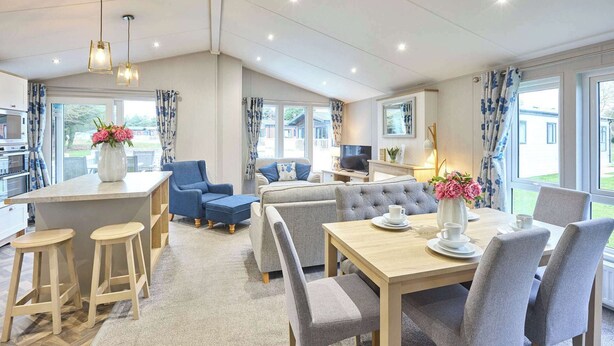 A modern kitchen with a dining area, a sofa set, and a TV. - Host & Stay | The Haven Lodge (Pocklington)