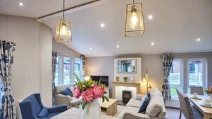 A modern living room with a sofa set, a dining table, and a fireplace. - Host & Stay | The Haven Lodge (Pocklington)
