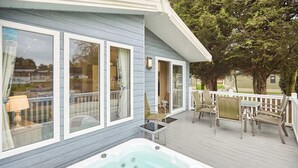 A spa suite with a hot tub, deck chairs, and a view of the surrounding area. - Host & Stay | The Haven Lodge (Pocklington)