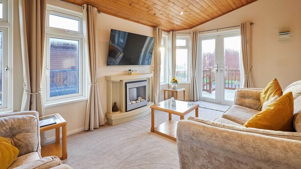 Ein Wohnzimmer mit Kamin, Fernseher und einer Couch.