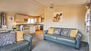 A living room with a sofa and a dining area with a kitchen. - Host & Stay | ORC02 Hidden Gem Lodge (Amotherby)