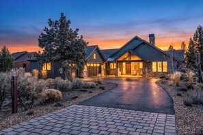 A modern house with a driveway leading to a garage, surrounded by landscaped gardens. - Peaceful Brasada Oasis | Hot Tub & Views (Powell Butte)