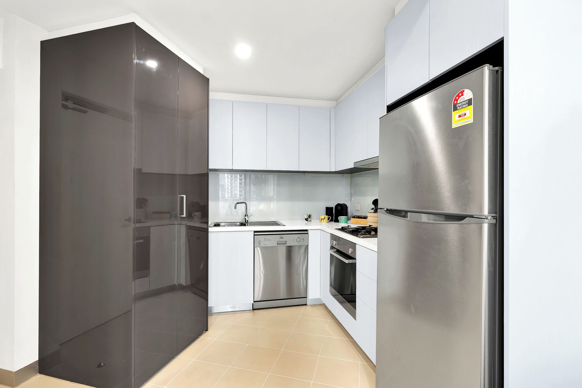 A modern kitchen with a stainless steel refrigerator, dishwasher, and oven.