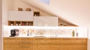 Una cocina con armarios de madera, encimera blanca y salpicadero con diseño.
