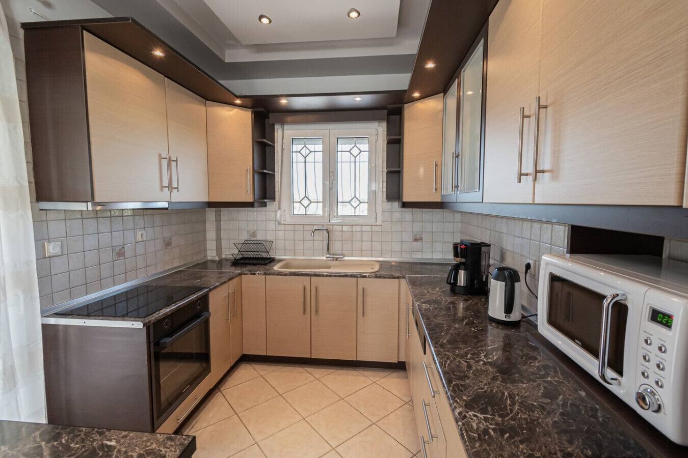 A modern kitchen with a built-in oven, microwave, and coffee maker.