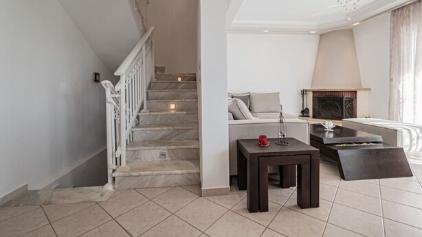 Een moderne woonkamer met een trap, een open haard en een salontafel.