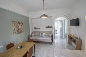 A modern living space with a dining area, sofa, TV, and artwork. - Forest View Apartment 1 by RentalsPro (Fourka)