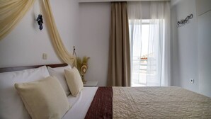 Une chambre d’hôtel avec un lit, des rideaux, une fenêtre et une lampe fixée au mur.