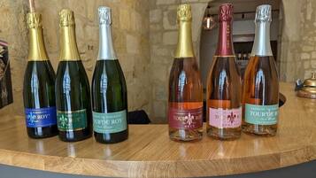A selection of wine bottles on a wooden surface with a stone wall and fireplace in the background.