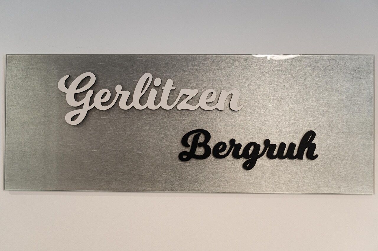 Um sinal com as palavras 'Gerlitzen' e 'Bergruh' em diferentes fontes.