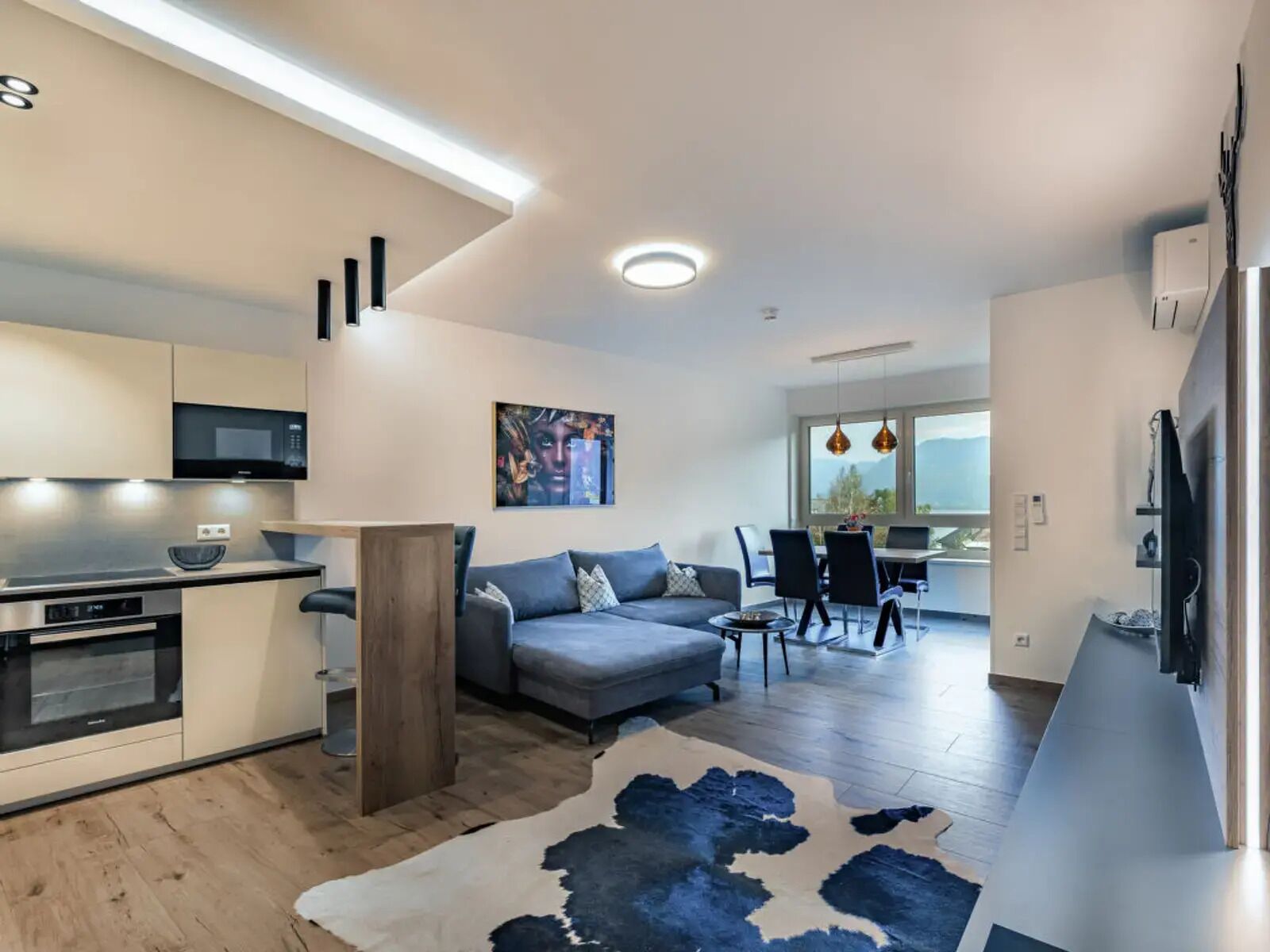 Un appartement moderne comprenant une cuisine, un coin repas et un salon.
