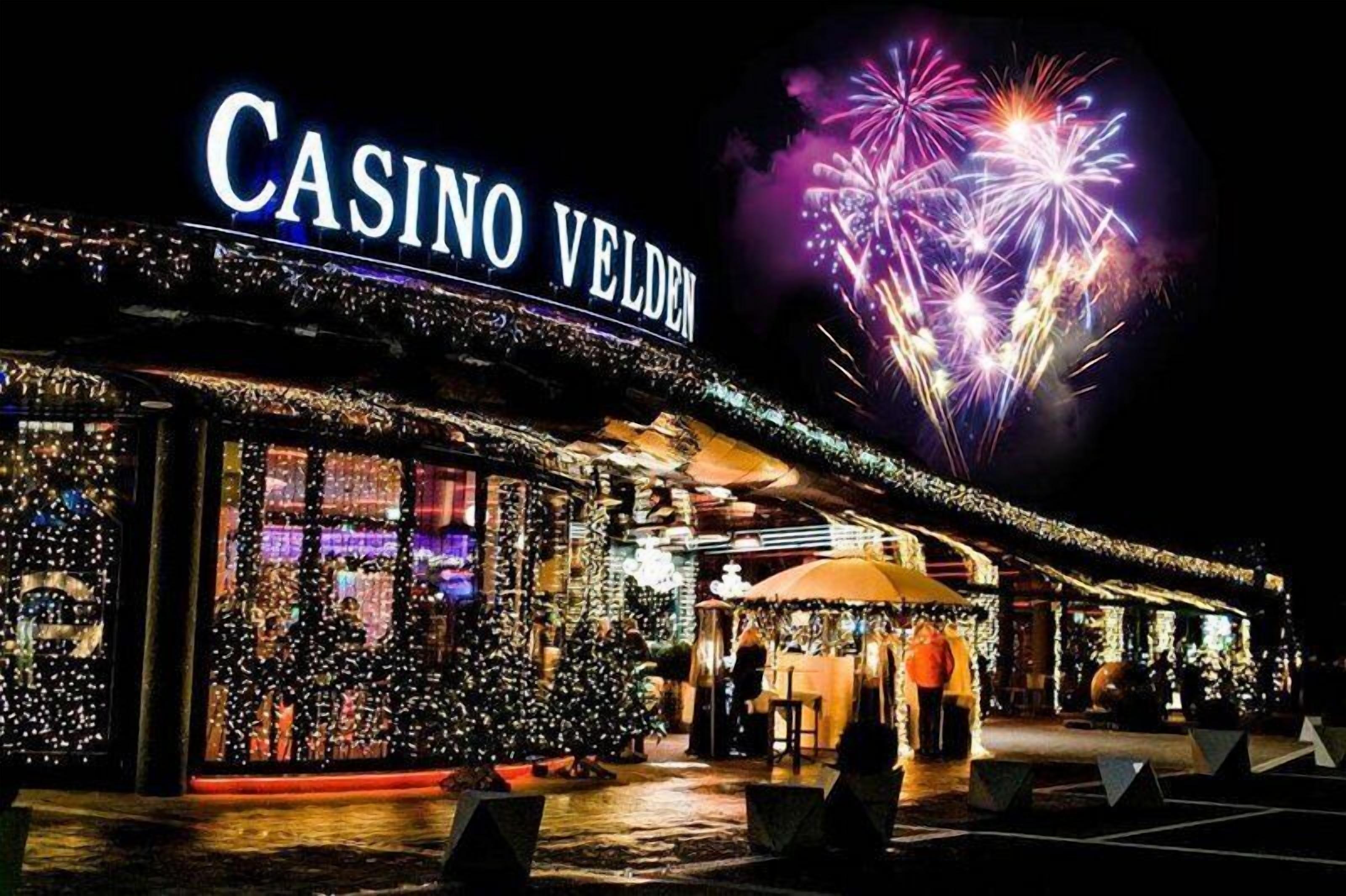 Un casino con un letrero que dice 'CASINO VELDEN' y un árbol de Navidad en primer plano.