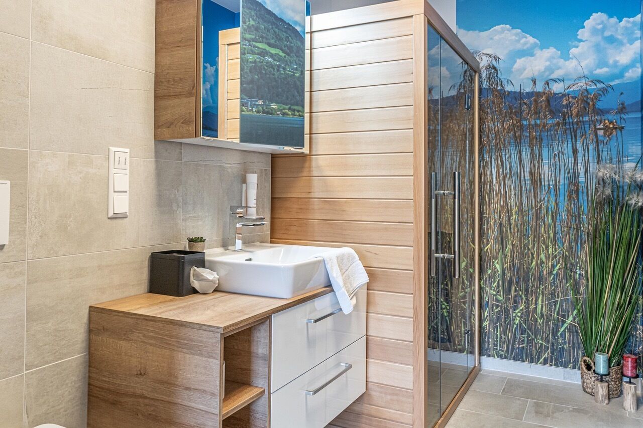 Un baño moderno con un ventanal grande, un lavabo y un mueble de tocador de madera.