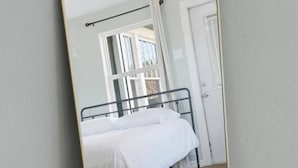 Un dormitori amb un llit, una finestra i una porta.