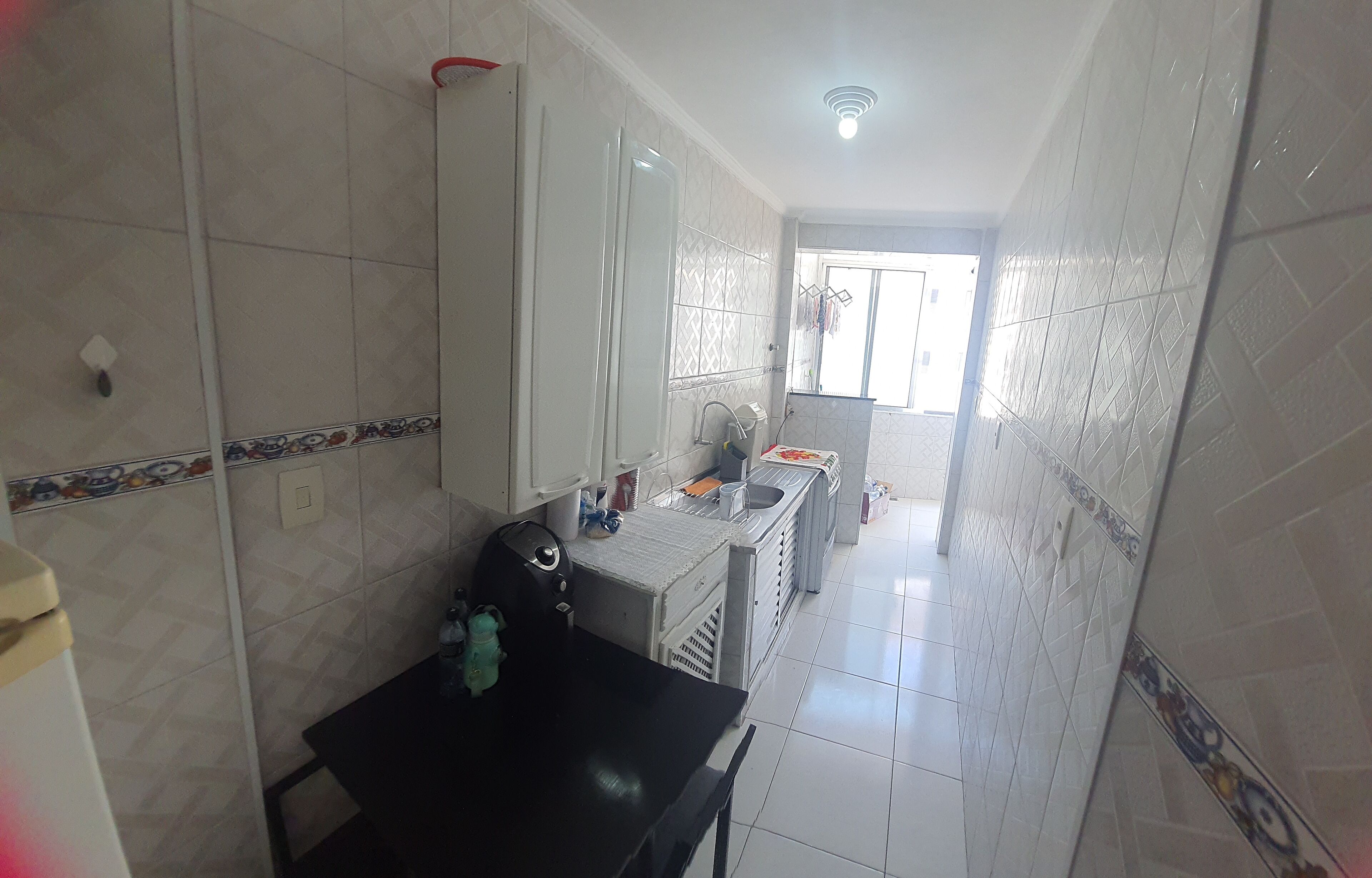 Un baño pequeño con ducha, inodoro y lavamanos.