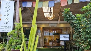 A yoga studio with a signboard, cactus plants, and a small garden area. - Fishermans Village Samui Yoga Retreat (Koh Samui)