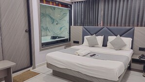 Una habitación de hotel moderna con una cama grande, una mesita de noche, una ventana con cortinas y una pared de mármol.