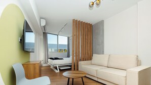 Un salon moderne comprenant un canapé, un fauteuil, une petite table et une cloison en bois.