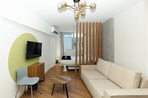 A modern living room with a sofa, a TV, a wooden cabinet, and a small table. - Located in the heart of Casco Viejo’s nightlife 🎶🌃<br>Steps from bars and nightclubs, perfect for those who want a lively vibe 🍸🕺<br>There is nighttime noise due to the nightclub area 🔊✨ (Casco viejo)