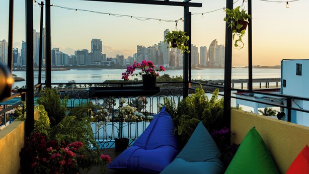 A balcony with a city view, potted plants, and colorful cushions. - Located in the heart of Casco Viejo’s nightlife 🎶🌃<br>Steps from bars and nightclubs, perfect for those who want a lively vibe 🍸🕺<br>There is nighttime noise due to the nightclub area 🔊✨ (Casco viejo)