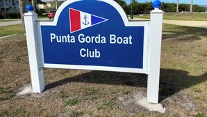 En skylt för Punta Gorda Boat Club med en blå bakgrund och vit text.