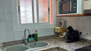 A kitchen with a double sink, a microwave, a toaster, and a stove. - Estartit Costa Brava. En bord de MER. Bel appartement avec vue sur la mer (L’Estartit (or Estartit))