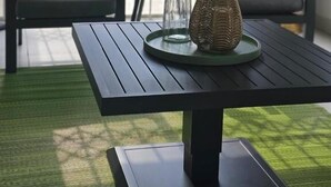 A patio with two chairs, a table, a decorative vase, and a glass container. - Greencroft Villa (Kempton Park)