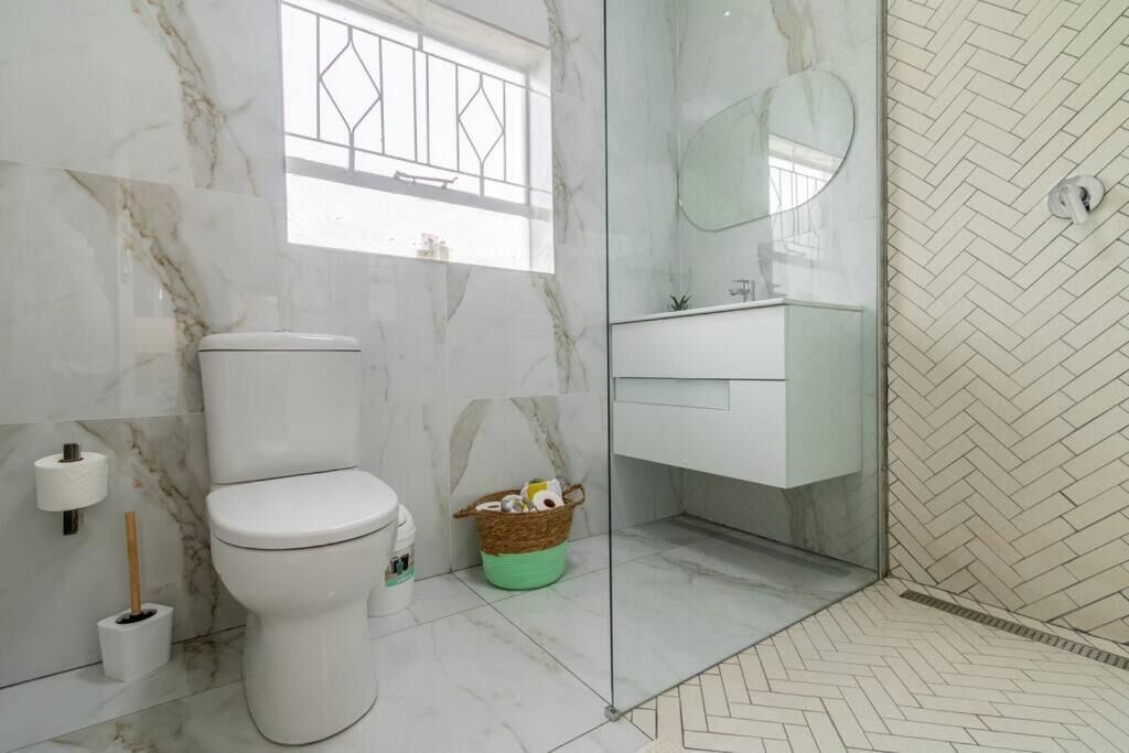 A bathroom with a toilet, bidet, and a glass-enclosed shower area.