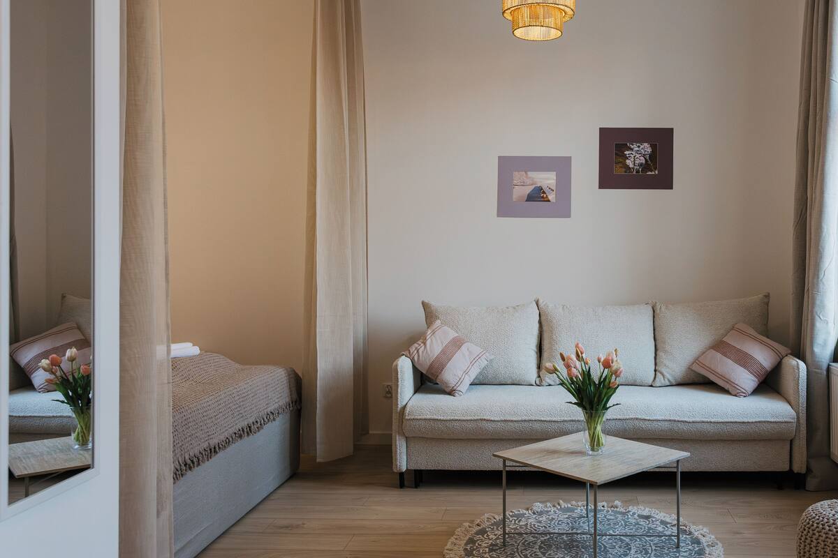 Una habitación acogedora con sofá, una mesita y una ventana con cortinas.