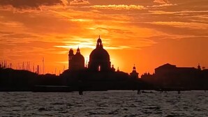 A silhouette of a cityscape with prominent domed buildings against a sunset sky. - Piccola Perla sul canale (Venezia)