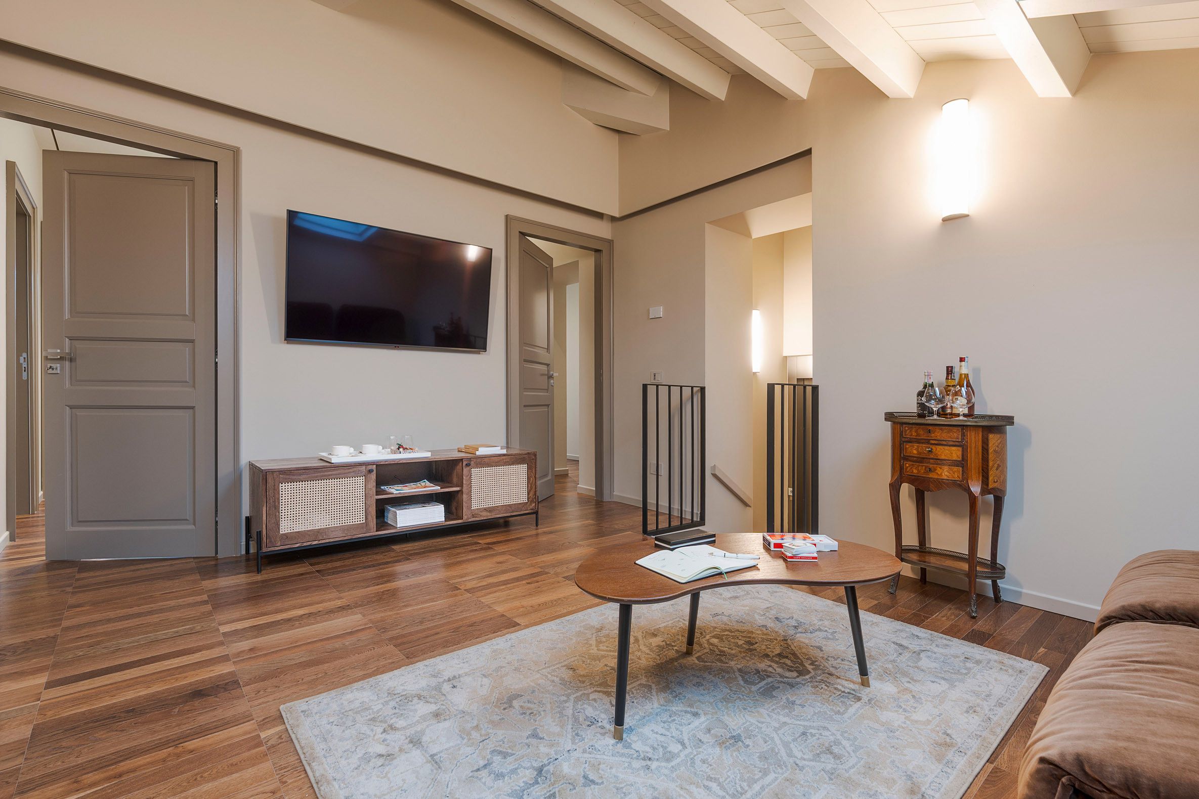 Ein stilvolles Wohnzimmer mit Flachbildfernseher, Couch und Couchtisch aus Holz.