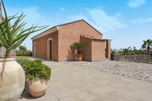 Un bâtiment doté d’un toit plat, d’une petite entrée et d’une cour dallée.
