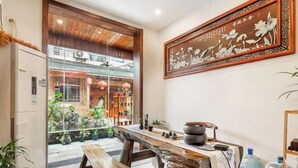 A wooden dining table with a bench, a refrigerator, a large water dispenser, and a traditional Chinese painting on the wall. - Just wait for you- English reception-Ticket reservation (Zhangjiajie)