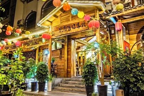 A traditional wooden building with a sign, potted plants, and hanging lanterns. - Just wait for you- English reception-Ticket reservation (Zhangjiajie)