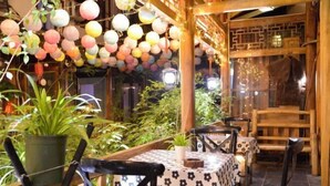 An indoor dining area with tables, chairs, hanging lanterns, and potted plants. - Just wait for you- English reception-Ticket reservation (Zhangjiajie)