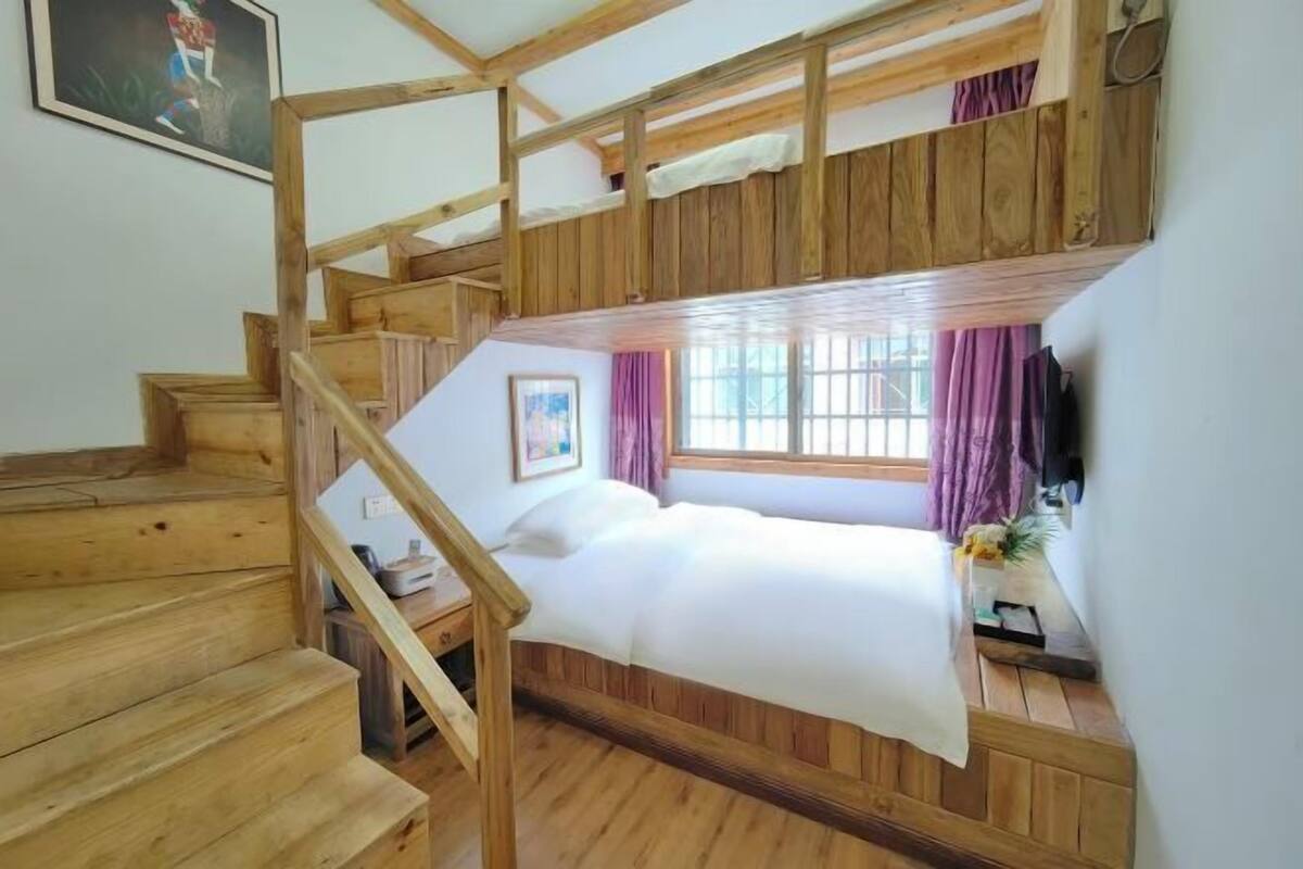 A bunk bed room with wooden walls and a staircase.
