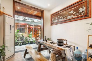 A traditional interior with a wooden table, a refrigerator, and a large framed artwork on the wall. - Just wait for you- English reception-Ticket reservation (Zhangjiajie)