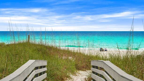 A pathway leading to a beach with clear turquoise water and a distant view of people on the shore. - Endless Escape A10-Beach Access-Sleeps 2 (Panama City Beach)