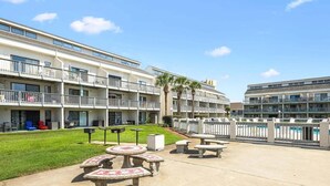 A hotel with a pool, outdoor seating, and a well-maintained lawn. - Endless Escape A10-Beach Access-Sleeps 2 (Panama City Beach)