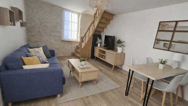 Una sala de estar moderna con un sofá azul, una mesa de centro de madera, una mesa de comedor y una escalera.