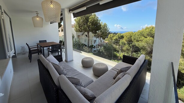 A balcony with a sofa, dining table, chairs, and hanging lights. - Exklusiv Sea View Villa with Pool in Paguera Mallorca Southwest (Peguera)