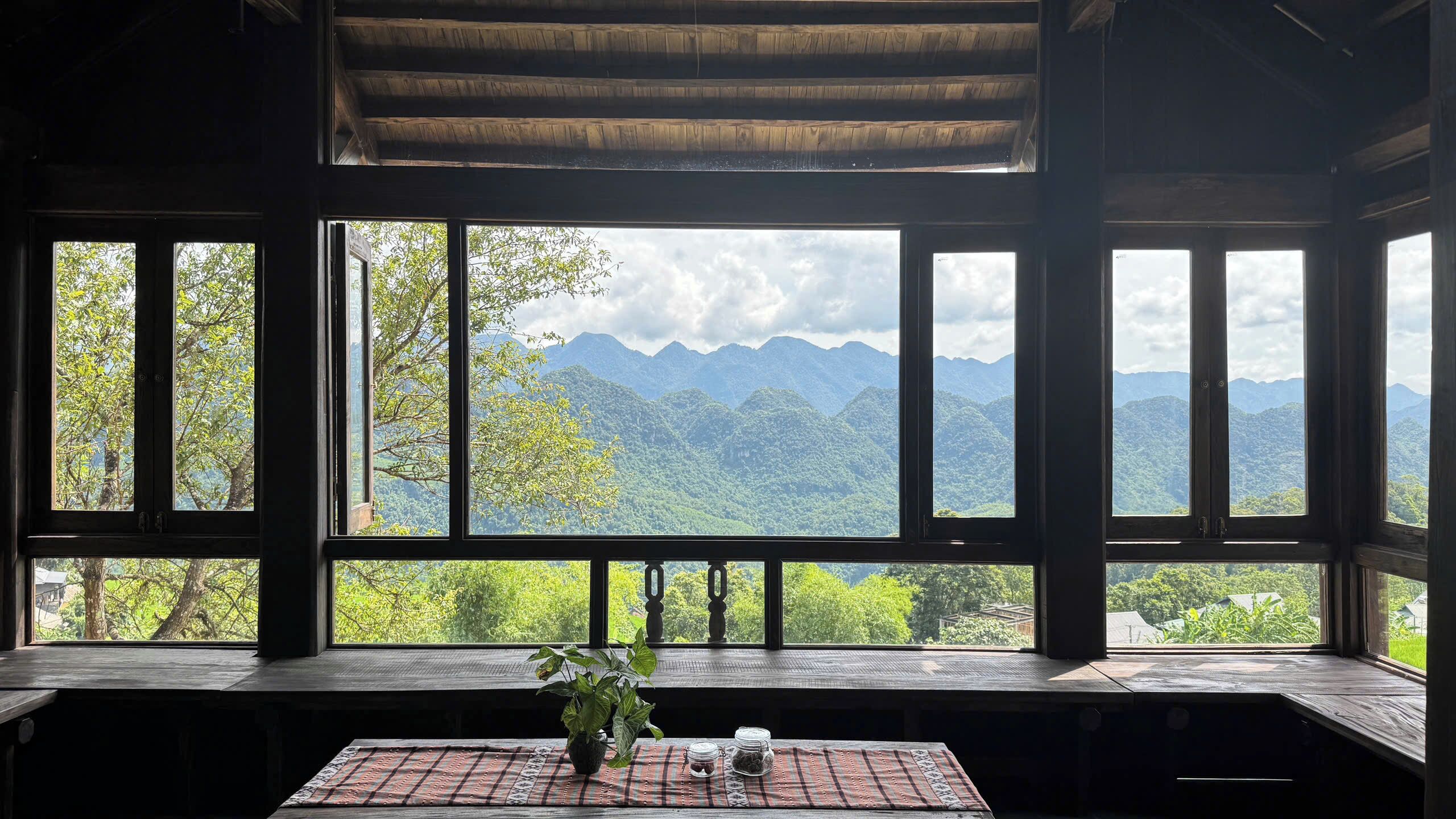 A room with large windows offering a view of mountains and trees.